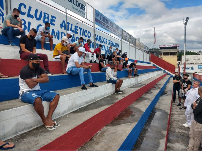 Jogadores do Brusque ouvem o médico, sentados e devidamente afastados na arquibancada / Fotos: Rodrigo Santos / TV Brusque