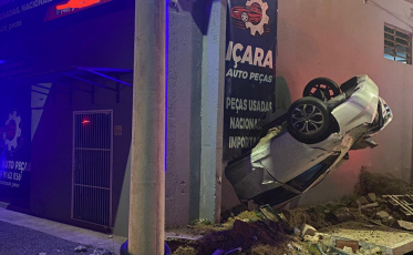 Içara: Após colisão, carro fica suspenso em parede de comércio e motorista foge