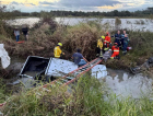 Carro capota e fica parcialmente submerso em sanga na BR-101