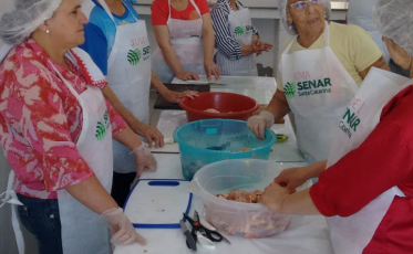 Mulheres passam por capacitação sobre preparo de frangos