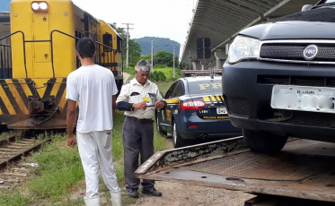 Veículo abandonado é removido dos trilhos instantes antes de passagem de trem