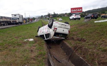 Motorista capota carro e cai na vala da BR-101, em Sangão