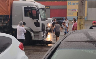 Motociclista fica ferido após cair embaixo de caminhão