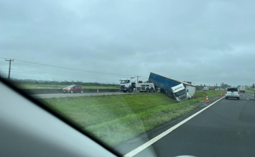 Carreta tomba no canteiro central da BR-101 e trânsito flui em meia pista