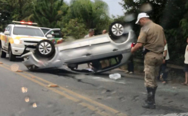 Carga cai de caminhão, veículo colide e capota