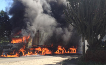 Carreta baú pega fogo e chamas atingem a rede elétrica