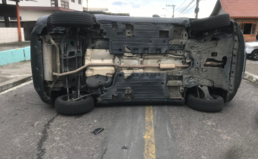 Após colidir em veículo estacionado, carro tomba em Criciúma