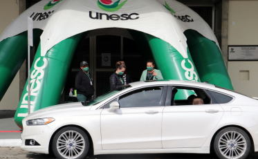 Em drive thru, estudantes do Colégio Unesc recebem apostilas