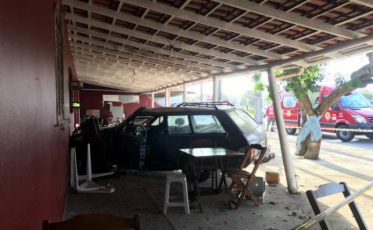 Após colisão com caminhão, carro invade estabelecimento comercial