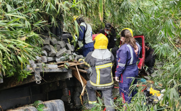 Braço do Norte: Caminhão cai em córrego e motorista fica preso às ferragens